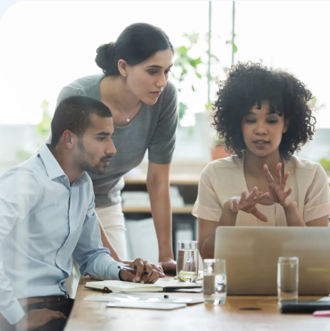 Woman with black curly hair wearing a backpack in a hallway holding and about to tap a phone